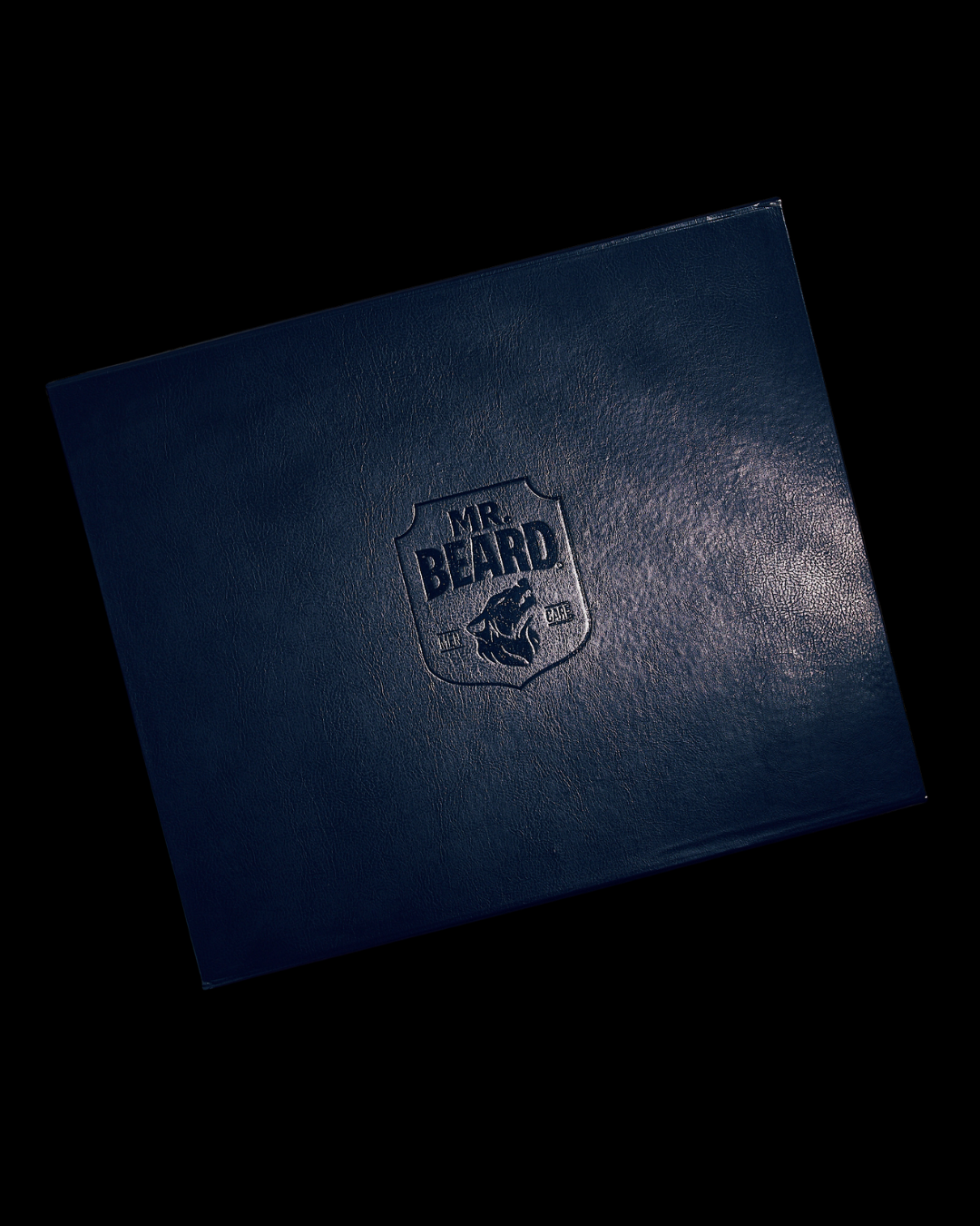 Dark blue leather-bound book with 'MR. BEARD' embossed logo on a black background