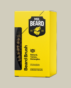 Yellow packaging of Mr. Beard beard brush with black text and logo on a black background