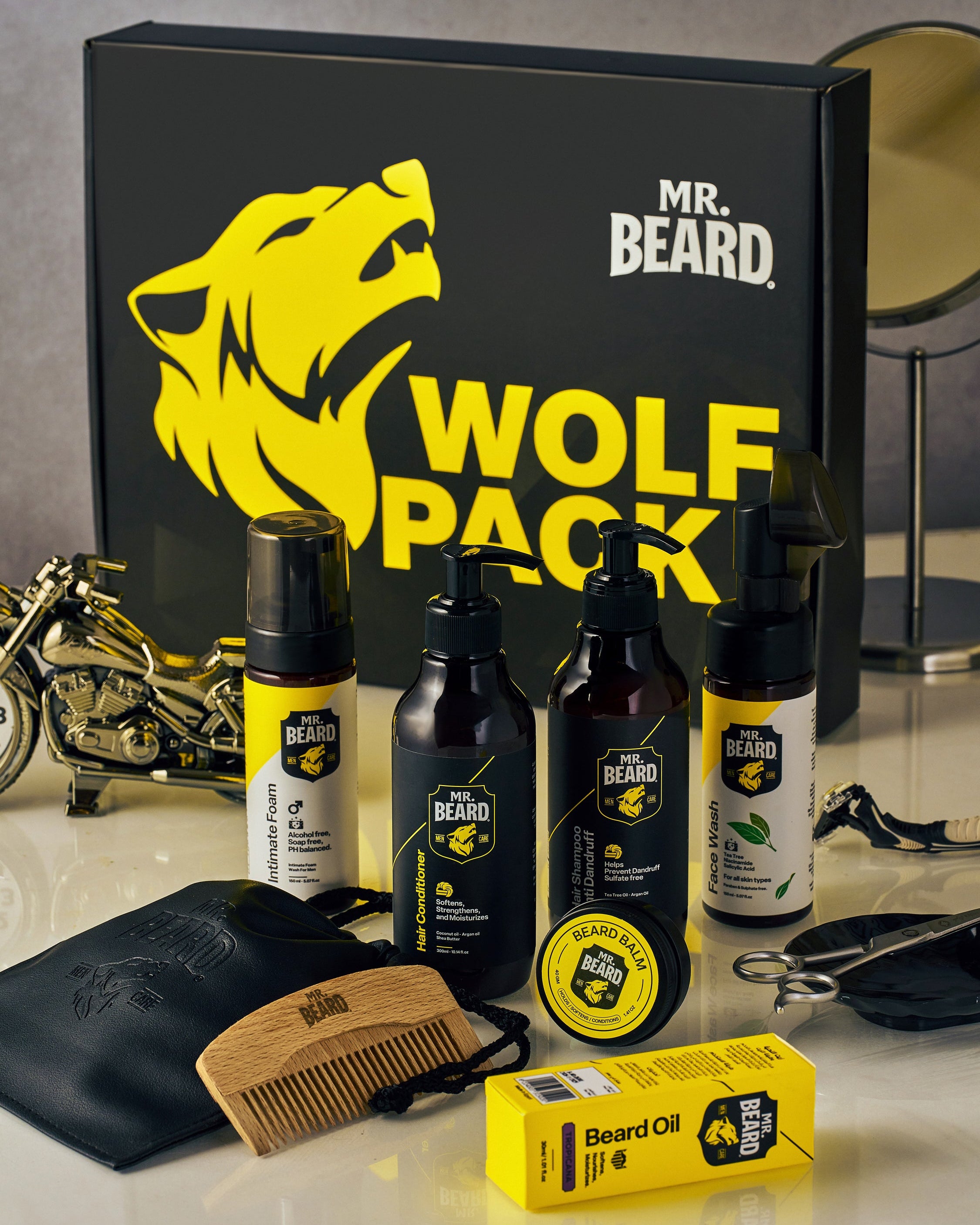 Mr. Beard Wolf Pack grooming kit with bottles, oil, and accessories on a reflective surface.