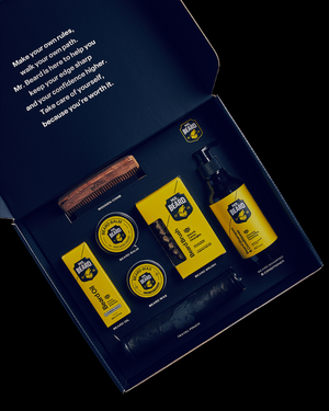 Beard grooming kit with bottles, a comb, and other items in a branded box.