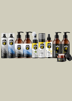 A lineup of various beard care products from Beard Care, including bottles, sprayers, and jars, arranged against a solid light beige background.